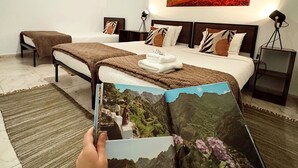 Ein modernes Schlafzimmer mit einem großen Bett, einem Baumgemälde und einem Buch auf dem Bett.