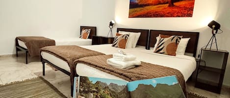 Quarto moderno com uma cama grande, um quadro de uma árvore e um livro na cama.