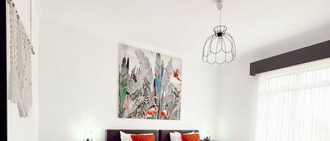 A modern bedroom with a large bed, two nightstands, a ceiling light, and a large window with sheer curtains.