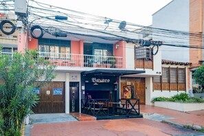 Un restaurant doté d’une terrasse, d’un balcon et d’une enseigne indiquant « Bazar ».