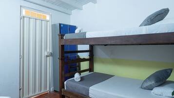 A bunk bed with a grey mattress and pillows, a wooden headboard, and a blue storage unit against the wall.