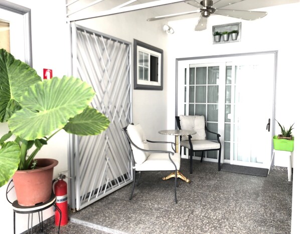 Relax in a secure, outdoor space with a seating area and ceiling fan.