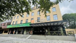 A multi-story building with a covered entrance and a green awning. - James Joyce Coffetel Shanghai Zhuanqiao Wanda Plaza (ex Shanghai James Joyce Coffetel Zhuan Bridge W (Shanghai)