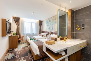 A hotel room with a large bed, a vanity with a mirror, a desk, and a large window with curtains. - James Joyce Coffetel Shanghai Zhuanqiao Wanda Plaza (ex Shanghai James Joyce Coffetel Zhuan Bridge W (Shanghai)