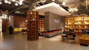 A modern interior with a central fireplace, wooden shelving, and a coffee bar area. - James Joyce Coffetel Shanghai Zhuanqiao Wanda Plaza (ex Shanghai James Joyce Coffetel Zhuan Bridge W (Shanghai)
