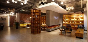 A modern interior with a central fireplace, wooden shelving, and a coffee bar area. - James Joyce Coffetel Shanghai Zhuanqiao Wanda Plaza (ex Shanghai James Joyce Coffetel Zhuan Bridge W (Shanghai)