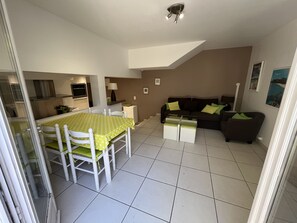 A compact living space with a dining area, a sofa, and a TV.