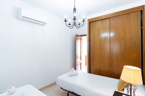 Une chambre d’hôtel équipée d’un lit, d’une lampe de chevet, d’une armoire et d’un appareil de climatisation.
