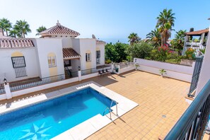 Propiedad residencial con piscina, un patio cubierto y vista al mar.