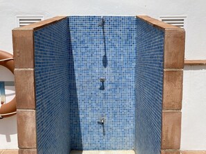 A blue-tiled shower enclosure with a metal faucet and a drain. - Chimenea Pinar 2 Apartment by Casasol (Nerja)
