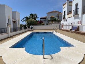 A rectangular swimming pool with a metal ladder, surrounded by a tiled deck. - Chimenea Pinar 2 Apartment by Casasol (Nerja)