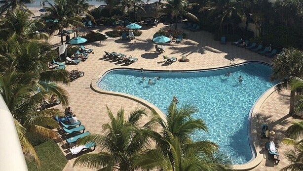 Un resort con piscina, spiaggia e vista sull'oceano.