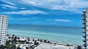 Un hotel di grandi dimensioni con vista su una spiaggia, sotto cieli sereni.