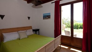 Un dormitorio con cama, una mesita y vistas al exterior.