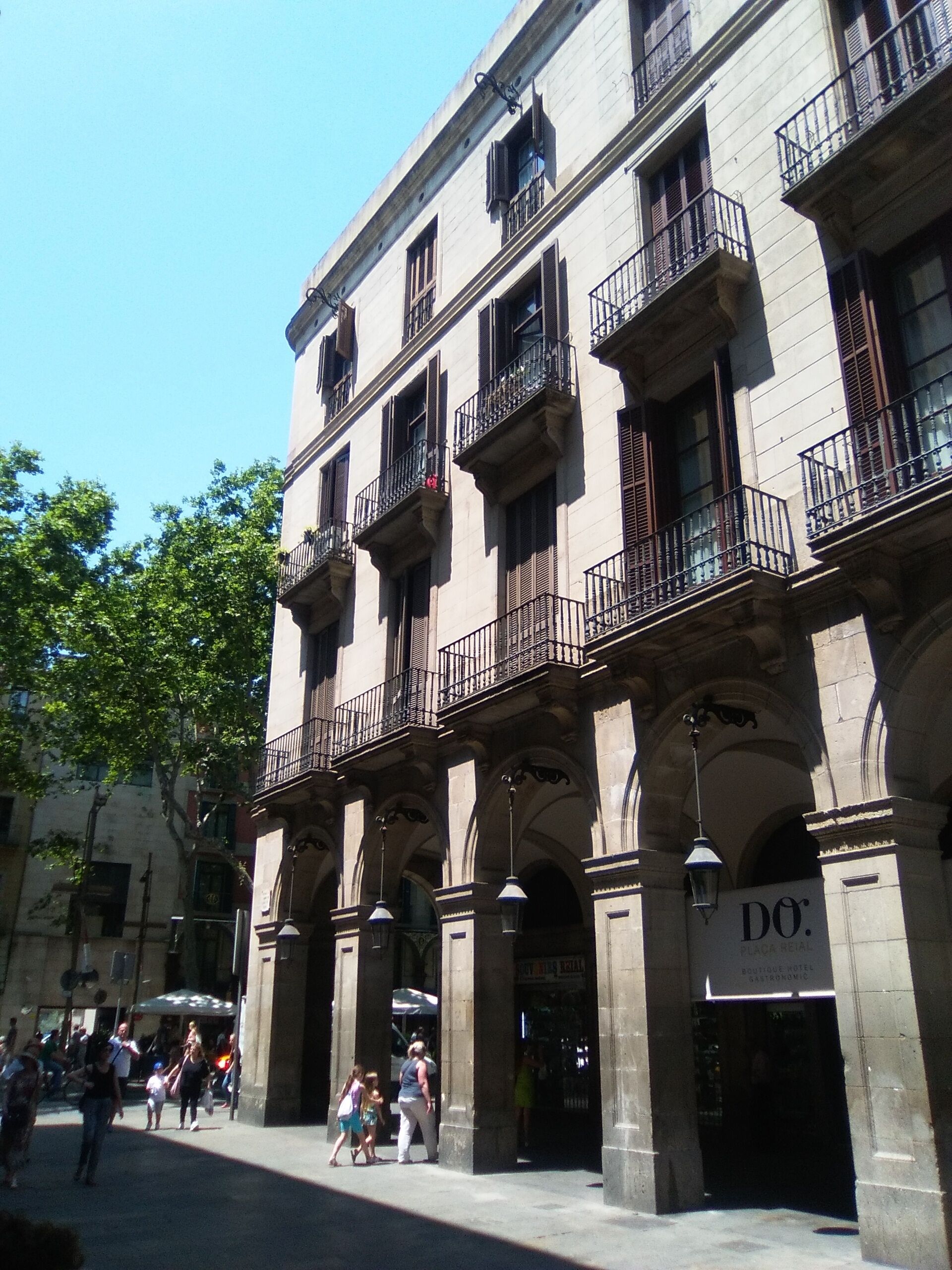 A historic building with multiple balconies and a sign for 'DO Boutique Hotel'.