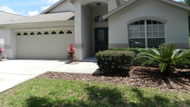 A single-story house with a garage, a front porch, and a well-maintained lawn.