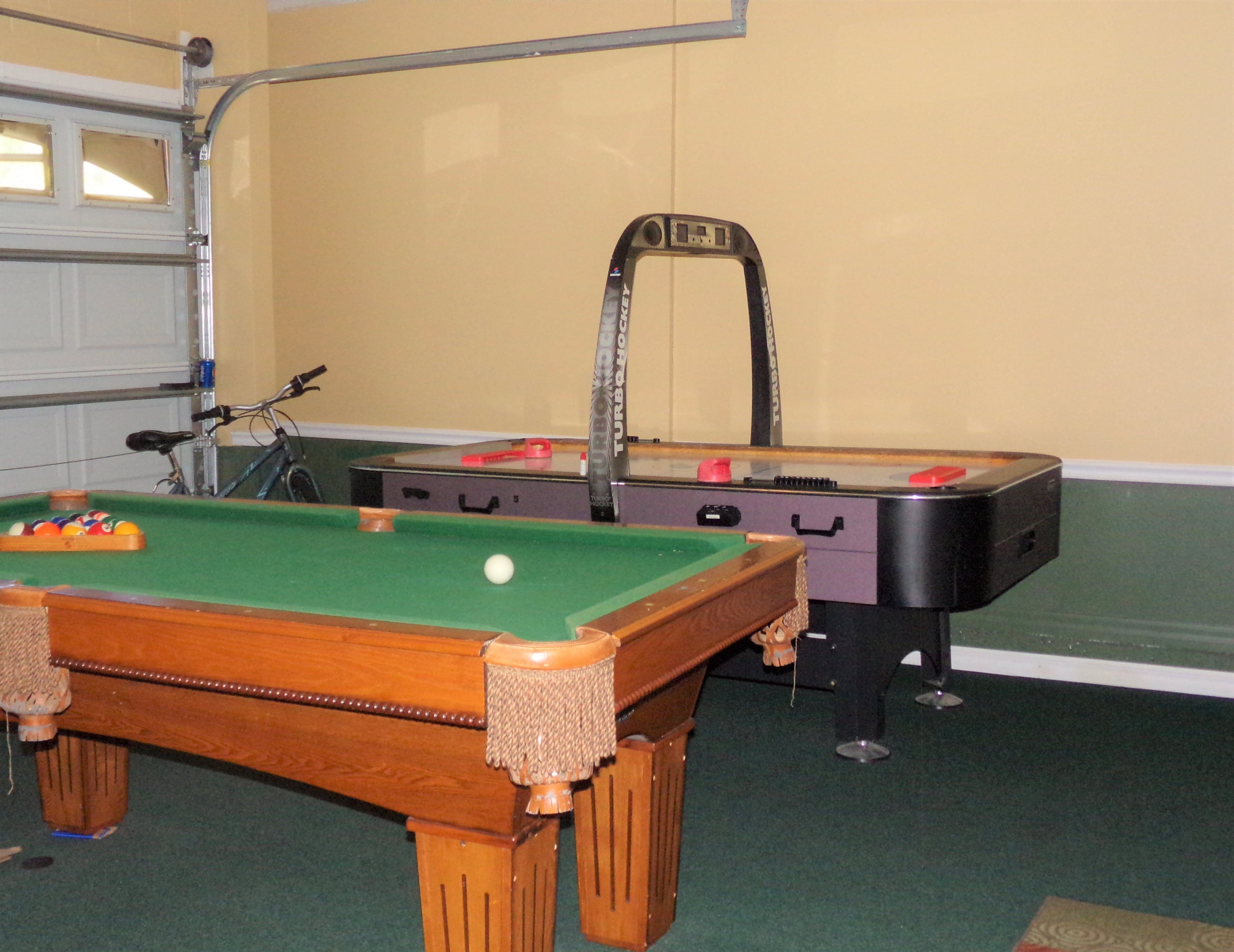 A pool table with a cue ball, a pool table with a red ball, and a pool table with a black ball.
