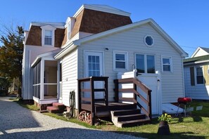 A two-story house with a front porch, a garage, and a small front yard.