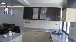 Una cucina con pensili scuri, un piano di lavoro in marmo e una stufa a gas.