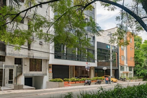 A modern building with a glass facade, a visible entrance, and a sign indicating a business or commercial use. - Hotel Loft 32 (Medellín)