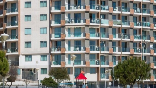 A multi-story hotel with a modern architectural design, featuring balconies on each floor and large windows.