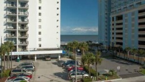 Un hotel de varios pisos con estacionamiento y vista al océano.