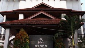 A tall building with a modern facade and a sign for 'asana'. - Asana Kawanua Jakarta (Jakarta)