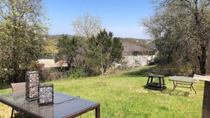 An outdoor patio with a glass table, chairs, and a small table. - Cozy 3-Bdrm  Escape w/ Yard - Budget-Friendly (Austin)