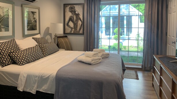 A bedroom with a bed, a window, and a view of the outside. - Charming, newly renovated house, a few steps from bike path. (Dennis Port)