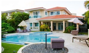 A two-story house with a swimming pool, outdoor furniture, and a covered patio area. - Villa Esmeralda Cocotal Golf & Country (Punta Cana)