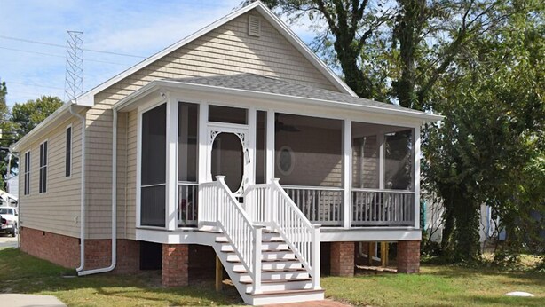 A single-story house with a front porch, a staircase leading to the entrance, and a brick foundation. - 2 BR | Screened Porch | Walk to Town (Chincoteague)