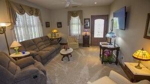 A living room with a sofa, armchairs, a coffee table, and a television. - 2 BR | Screened Porch | Walk to Town (Chincoteague)