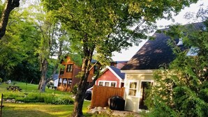 A residential area with a house, a wooden deck, and a lawn. - In-town Couples Getaway with Dockslipl (Holderness)