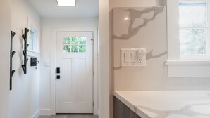 A modern bathroom with a marble countertop, a sink, and a window.