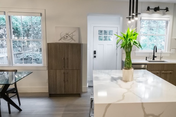 A view of the kitchen island, microwave cabinet & back door of the mud/coat room