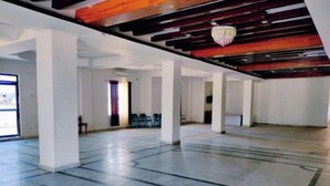 A spacious hall with a high ceiling, exposed wooden beams, and a chandelier. - Family Suite With Balcony 2 (Ramnagar)