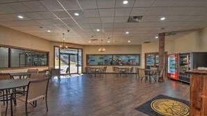 A spacious indoor area with wooden flooring, tables, chairs, a vending machine, and a large window. - Private Mountain Home in Gated River Resort with Lots of Amenities  (Ellijay)