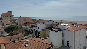 A coastal town with buildings featuring red-tiled roofs and a view of the sea. - Apartment with a/c far 50 m from the sea (Viareggio)