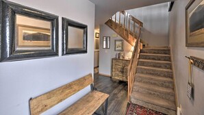 A staircase with wooden steps and a wooden railing, leading to a landing with a bench and a small table. - Nicely renovated two bedroom two bath Condo with Lake and Mountain Views! (Pagosa Springs)