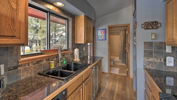 A modern kitchen with wooden cabinets, a large window, and a built-in sink. - Nicely renovated two bedroom two bath Condo with Lake and Mountain Views! (Pagosa Springs)