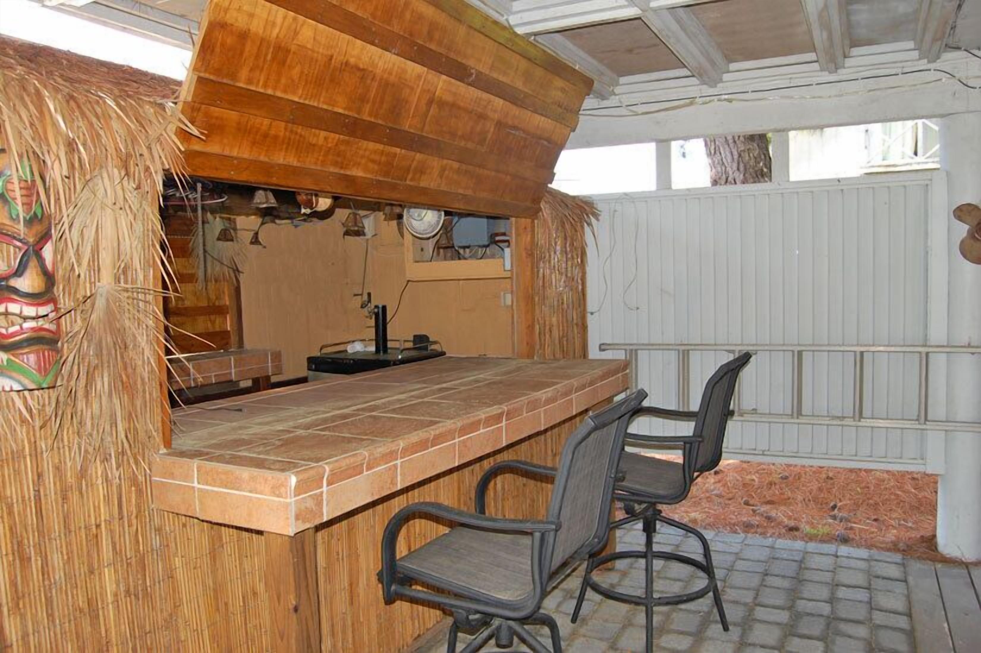 A bar area with a wooden counter and two chairs.