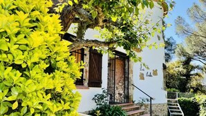 Un edificio blanco con una escalera de piedra que conduce a una puerta de madera.