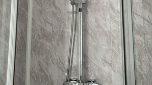 A modern shower with a handheld showerhead and a fixed showerhead, both mounted on a chrome fixture. - Large 3 bed House Sleep 10 Anfield Liverpool (Liverpool)