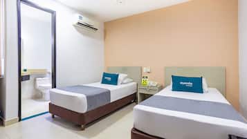Una habitación de hotel con dos camas, baño y minibar.