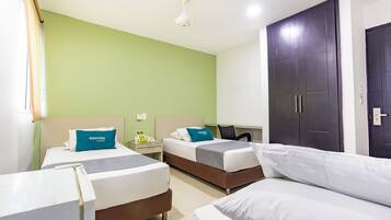 Habitación de hotel con dos camas individuales, un escritorio, una silla, un armario y una lámpara en el techo.