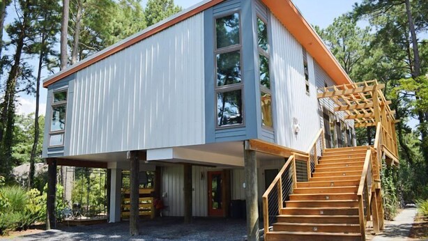 A modern two-story house with a wooden staircase and a covered outdoor area. - Tin Cup Palace- Community Boat Launch, Fire Pit & Screened Porch (Chincoteague)