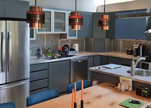 Enjoy cooking in this well-equipped kitchen with a refrigerator, dishwasher, and sink, perfect for preparing meals.