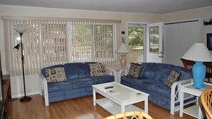 Ein Wohnzimmer mit zwei blauen Sofas, einem weißen Couchtisch und zwei Lampen.
