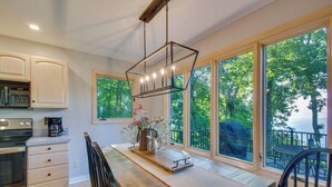 A modern kitchen with a built-in oven, a coffee maker, and a dining area with a table and chairs.