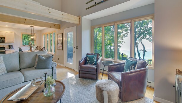 A spacious living room with a large window, a fireplace, and a dining area.